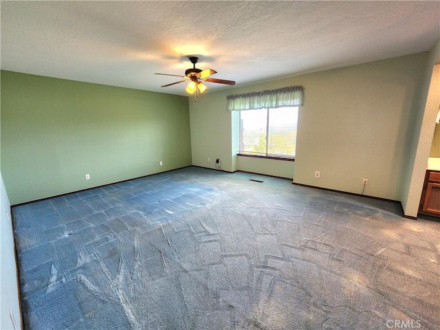 spare room featuring a textured ceiling, carpet floors, and ceiling fan