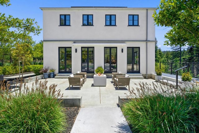 rear view of house with an outdoor living space, a patio, and french doors