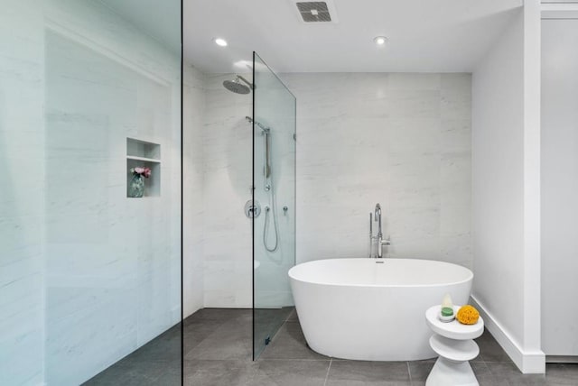 bathroom featuring tile walls and independent shower and bath