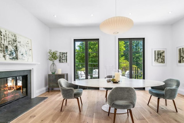 dining room with light hardwood / wood-style floors and french doors