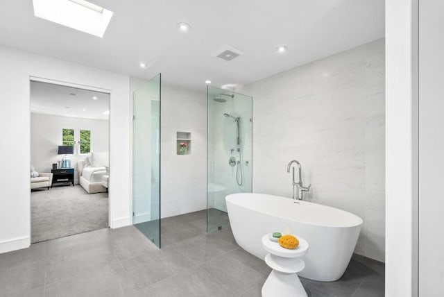 bathroom featuring a skylight, tile patterned floors, and shower with separate bathtub