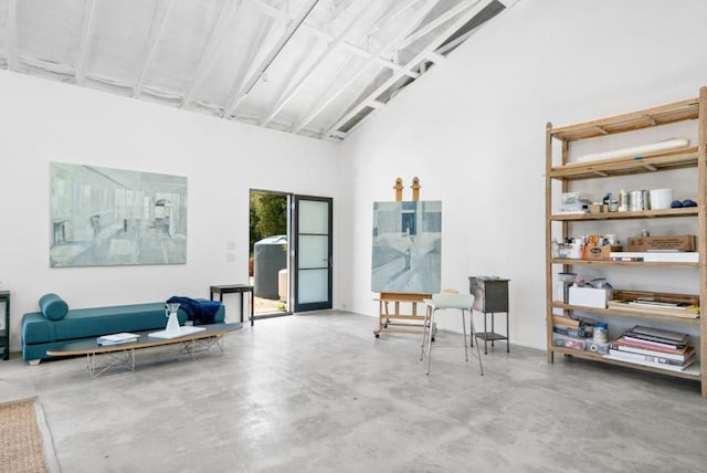 interior space featuring a towering ceiling and concrete flooring