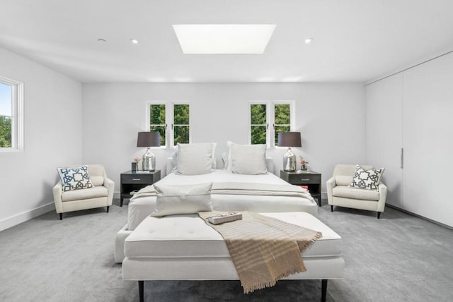 carpeted bedroom with a skylight and multiple windows