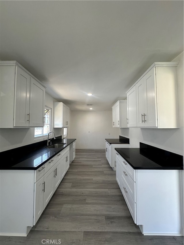 kitchen with sink, white cabinetry, and hardwood / wood-style flooring