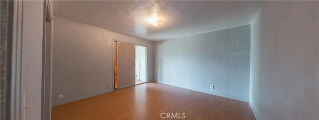 spare room with hardwood / wood-style floors and a textured ceiling