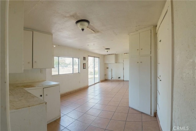 kitchen featuring light tile patterned floors and white cabinetry