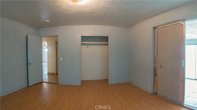 unfurnished bedroom with lofted ceiling, brick ceiling, and light wood-type flooring