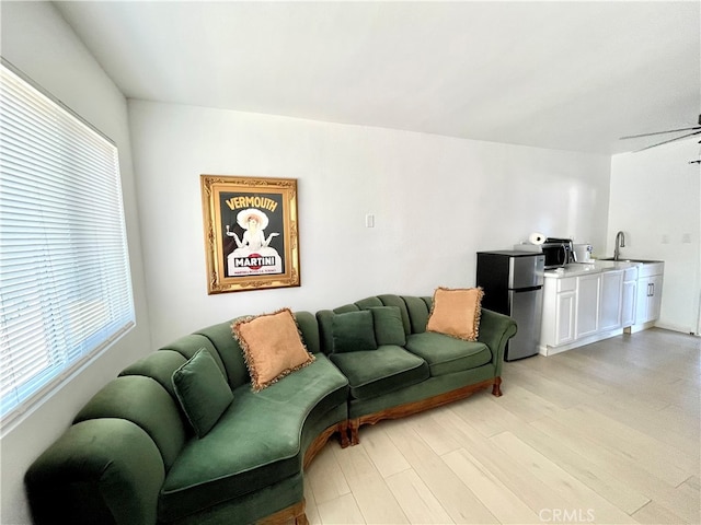 living room featuring ceiling fan and light wood-type flooring