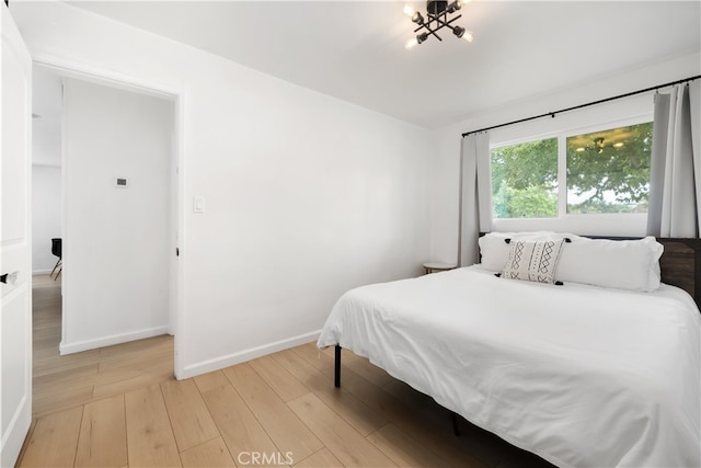 bedroom featuring light hardwood / wood-style flooring and a notable chandelier