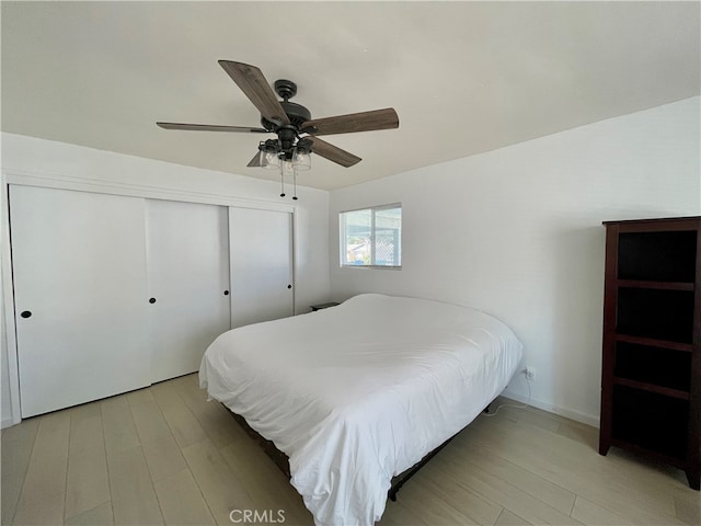 bedroom with hardwood / wood-style floors, a closet, and ceiling fan