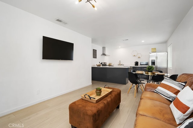 living room featuring sink and light hardwood / wood-style floors