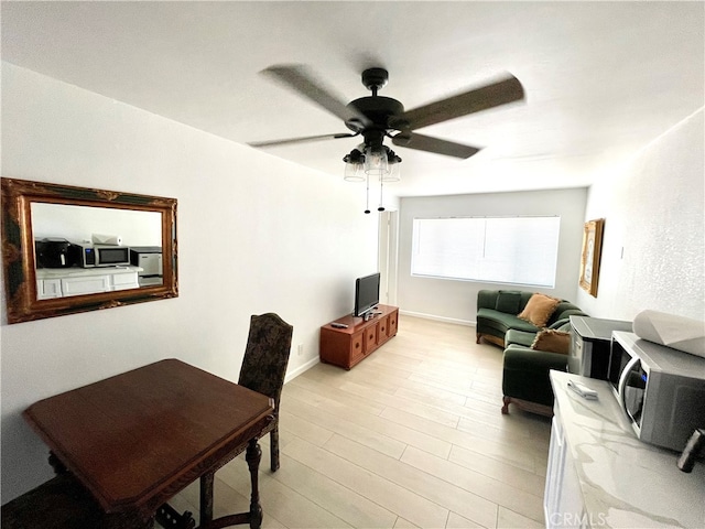 living room with ceiling fan and light hardwood / wood-style floors