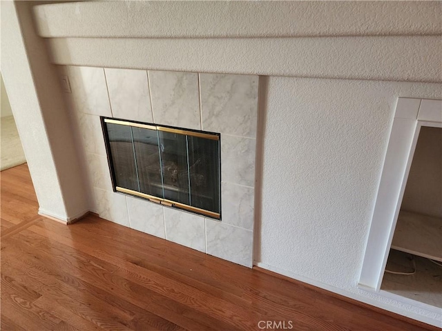 interior details featuring a tile fireplace