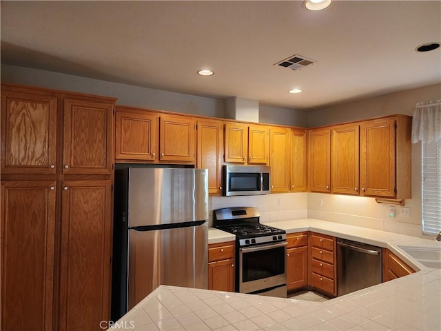 kitchen featuring appliances with stainless steel finishes, tile counters, and sink