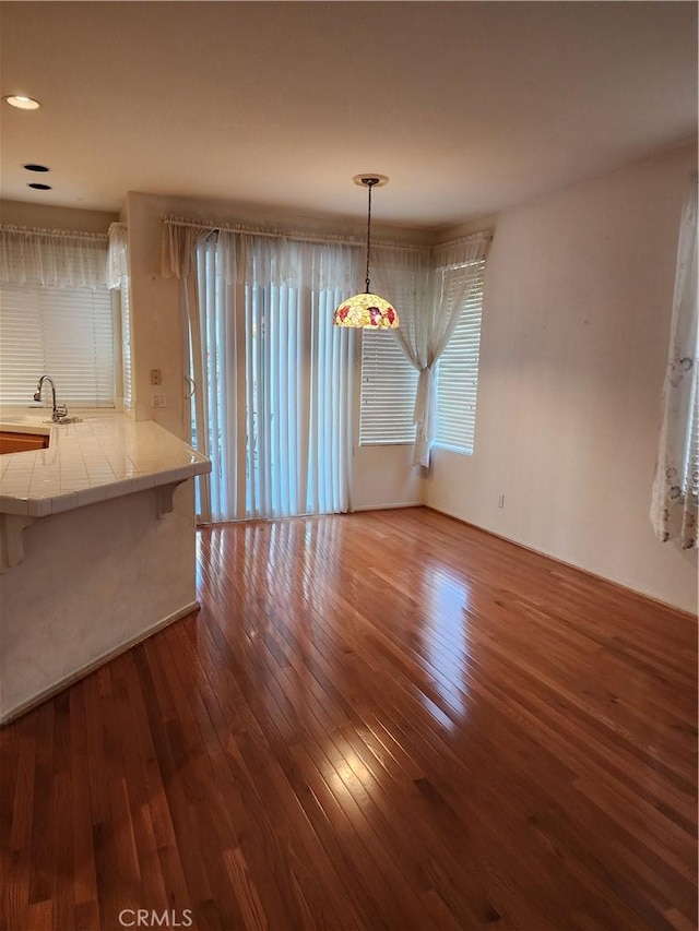 unfurnished dining area with hardwood / wood-style floors and sink