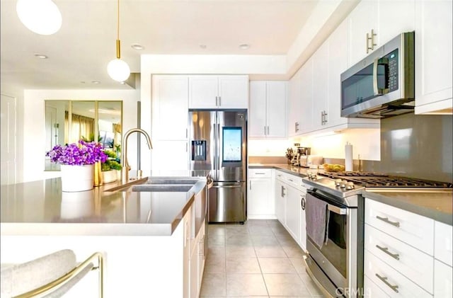 kitchen with white cabinetry, sink, hanging light fixtures, light tile patterned floors, and appliances with stainless steel finishes