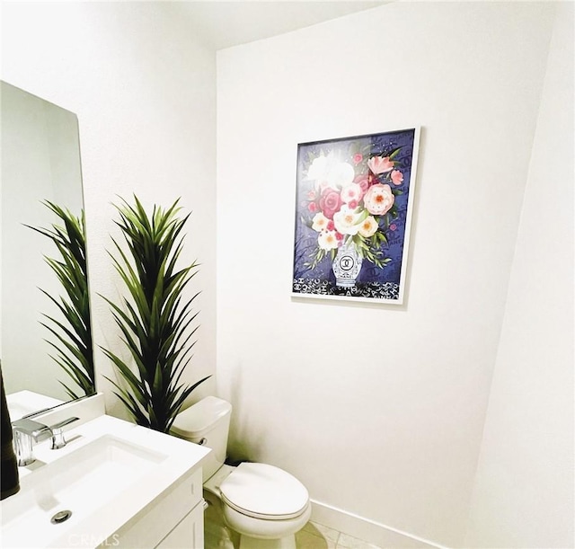 bathroom with tile patterned flooring, vanity, and toilet