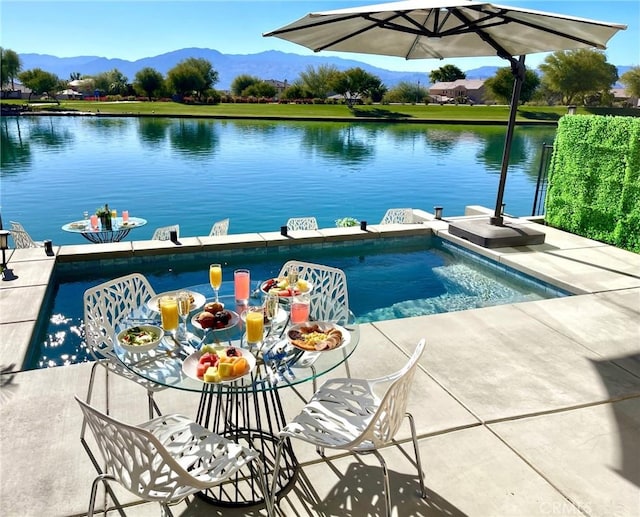 view of swimming pool with a water and mountain view