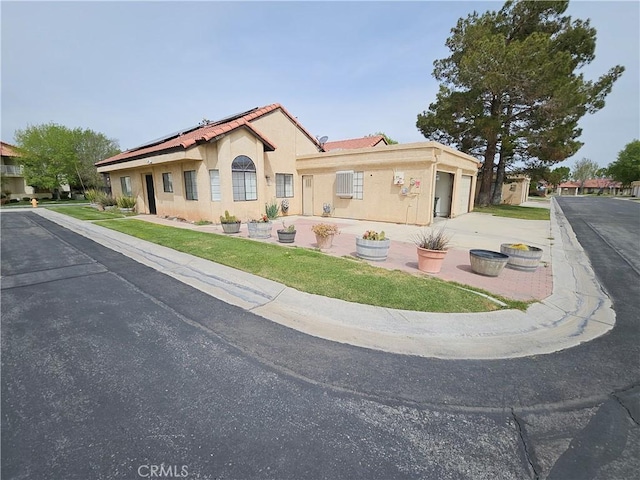 view of front facade featuring solar panels and a garage