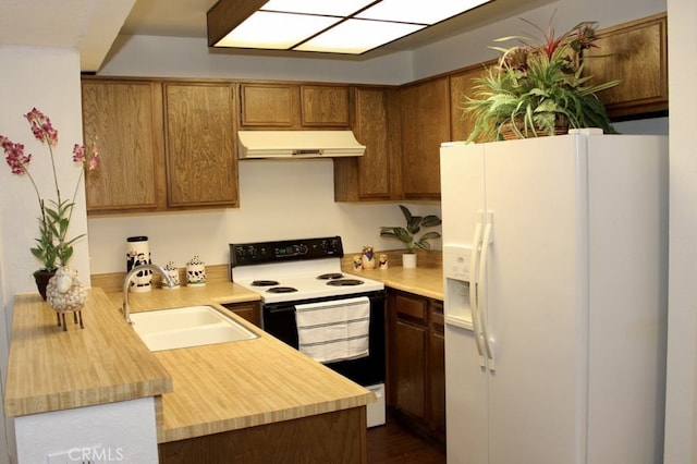 kitchen featuring kitchen peninsula, white appliances, and sink