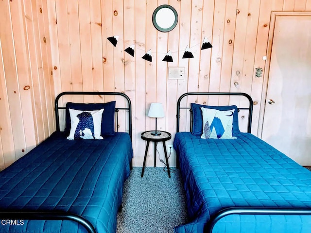 bedroom with wood walls and carpet floors