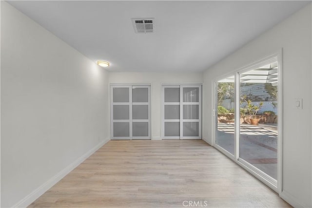 unfurnished room with light wood-type flooring