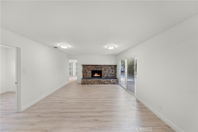 unfurnished living room with a fireplace and light wood-type flooring