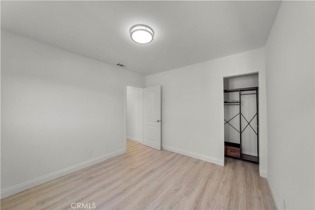 unfurnished bedroom featuring a closet and light hardwood / wood-style flooring