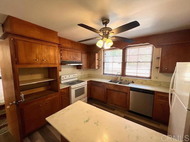 kitchen featuring ceiling fan, white appliances, dark hardwood / wood-style floors, and sink