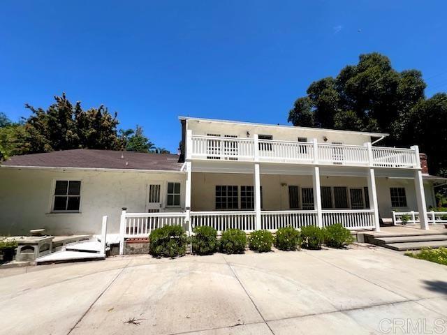 back of house featuring a patio and a balcony