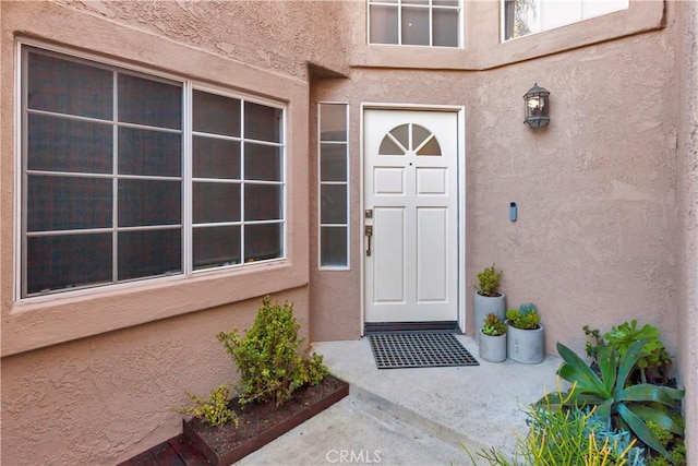 doorway to property featuring stucco siding