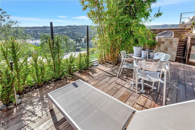 wooden deck featuring outdoor dining area and a mountain view