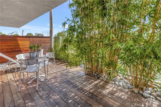 wooden deck featuring outdoor dining space and fence