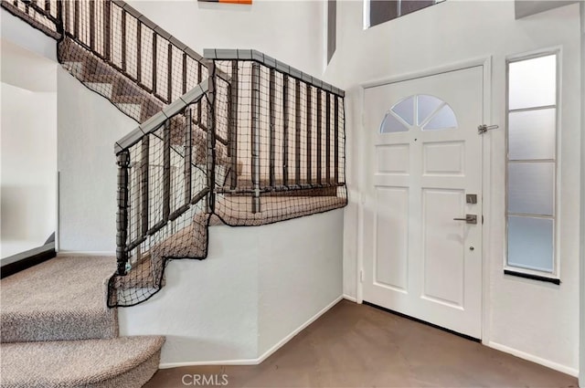 entrance foyer featuring baseboards and a high ceiling