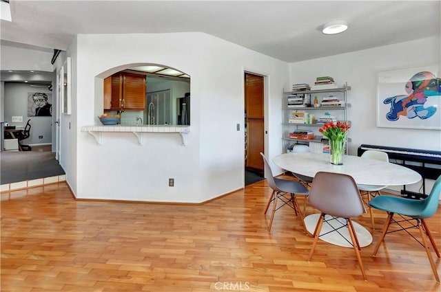 dining area with light wood-type flooring and baseboards