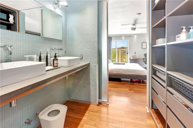 ensuite bathroom featuring a sink, wood finished floors, and ensuite bathroom