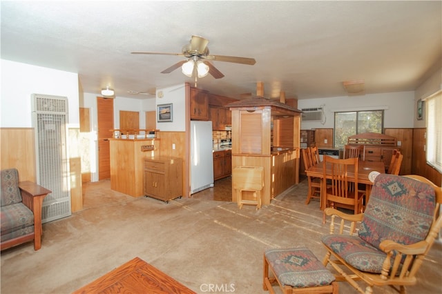 living room featuring wood walls, a wall mounted AC, light colored carpet, and ceiling fan