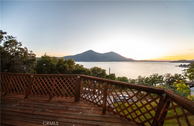 deck at dusk with a water and mountain view