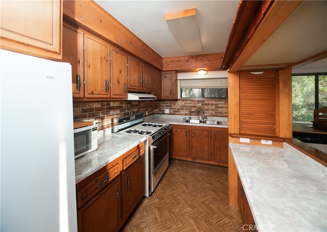 kitchen featuring backsplash, light parquet flooring, sink, and white appliances