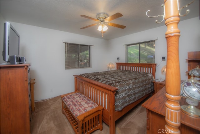 carpeted bedroom with ornate columns, ceiling fan, and a textured ceiling