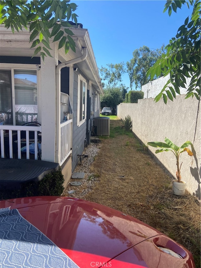 view of side of home featuring a deck and central AC