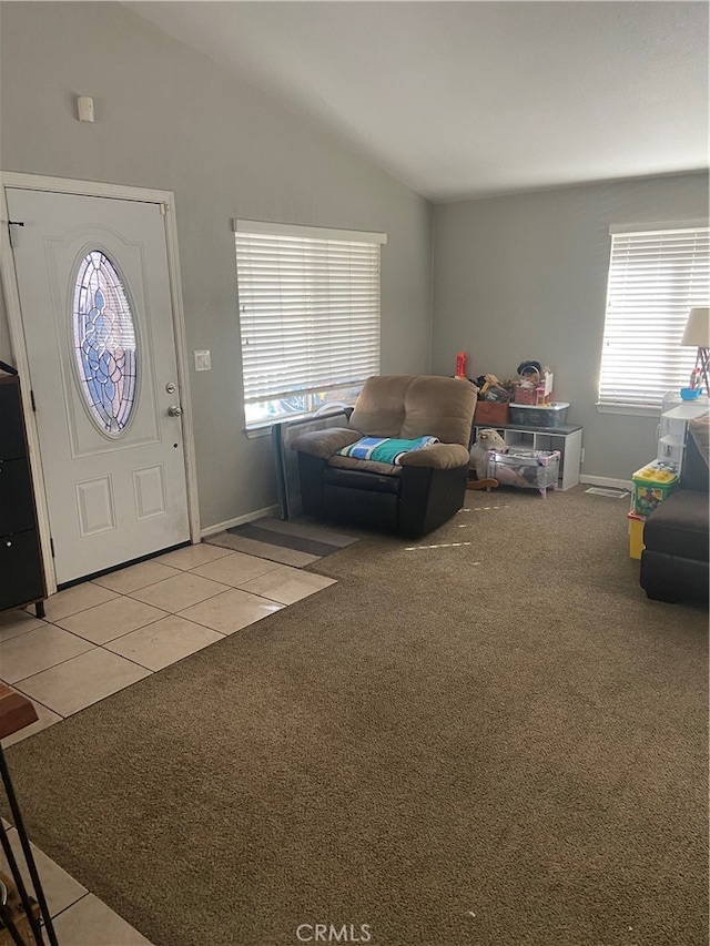 entrance foyer featuring light colored carpet and vaulted ceiling