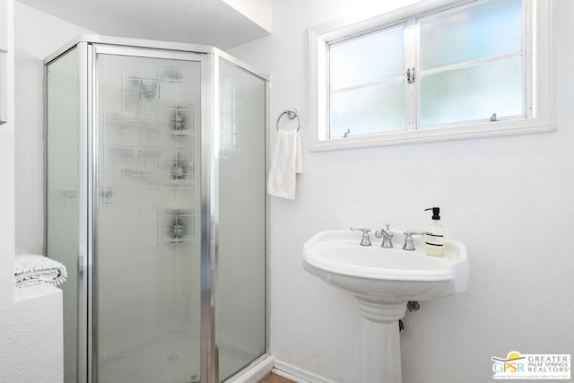 bathroom featuring a healthy amount of sunlight and a shower with door