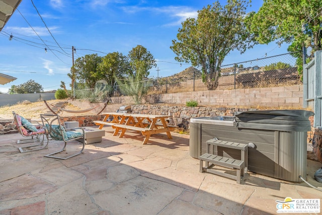 view of terrace with a hot tub