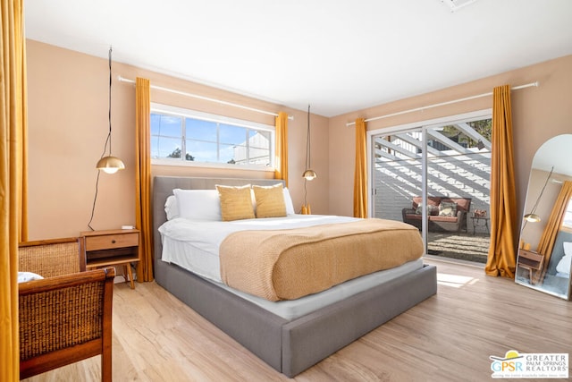 bedroom featuring light hardwood / wood-style flooring, access to exterior, and multiple windows