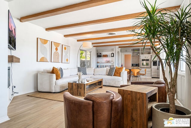 living room featuring beamed ceiling and light wood-type flooring