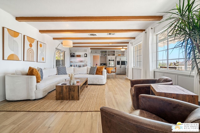 living room with beam ceiling and light wood-type flooring