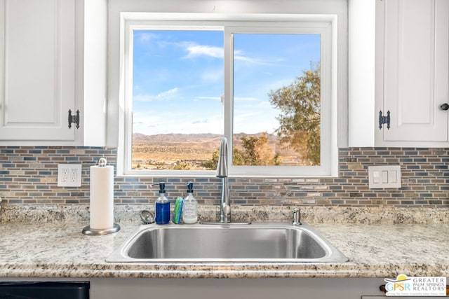 kitchen featuring sink, a healthy amount of sunlight, white cabinetry, and light stone countertops