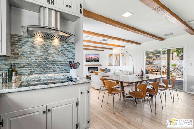 dining room with beamed ceiling and light hardwood / wood-style floors