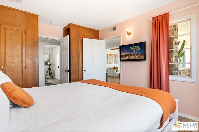 bedroom featuring a closet, multiple windows, and hardwood / wood-style flooring